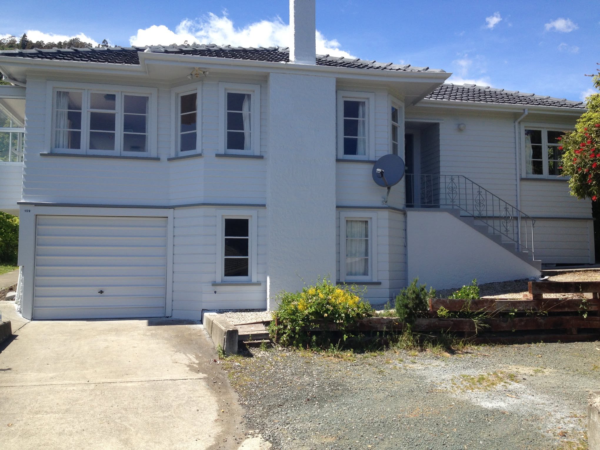 Same house finished in bright white with charcoal trim