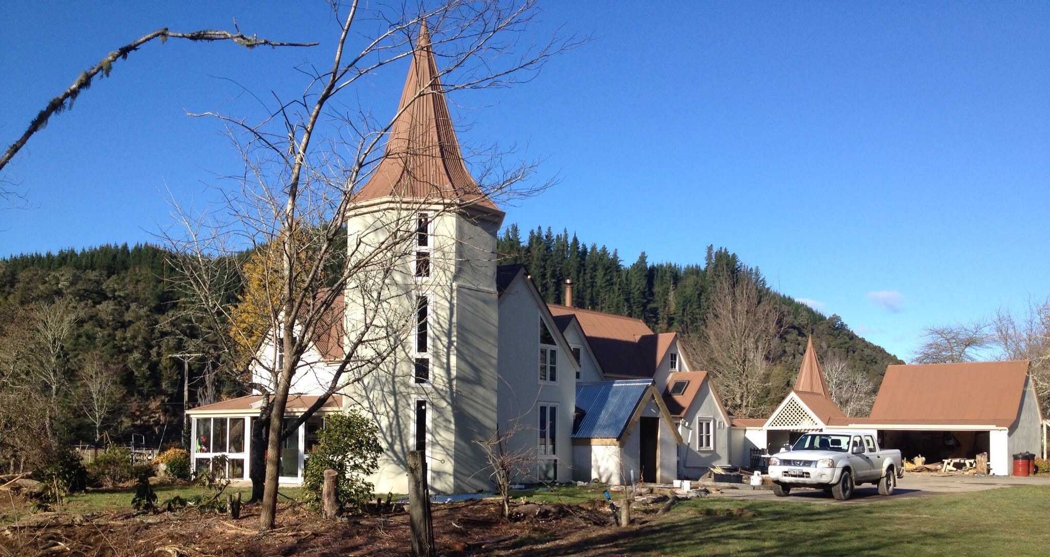 Cream character home with turret and terracotta roofs after exterior painting