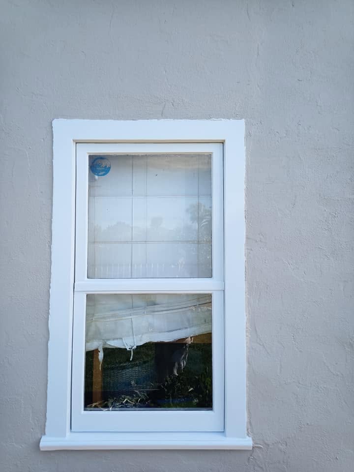 Same awning window cut in clean white against fresh stucco